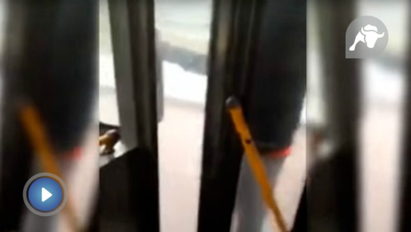 Un pasajero viaja colgado de la puerta de un bus porque el chófer no quiere abrir