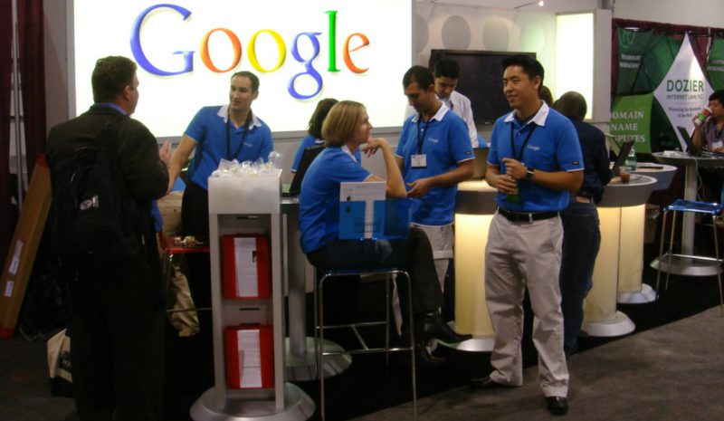 Un grupo de trabajadores de Google ante un stand de la compañía.