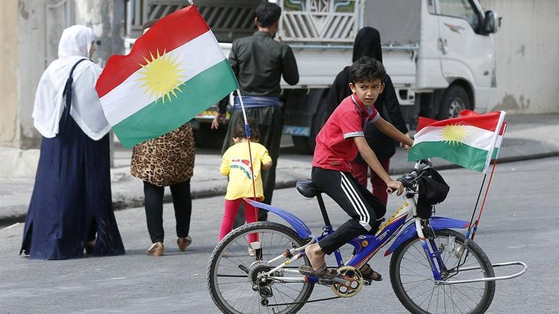 Un niño kurdo monta en bicileta