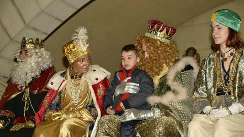 Los Reyes Magos entregando a los niños sus regalos