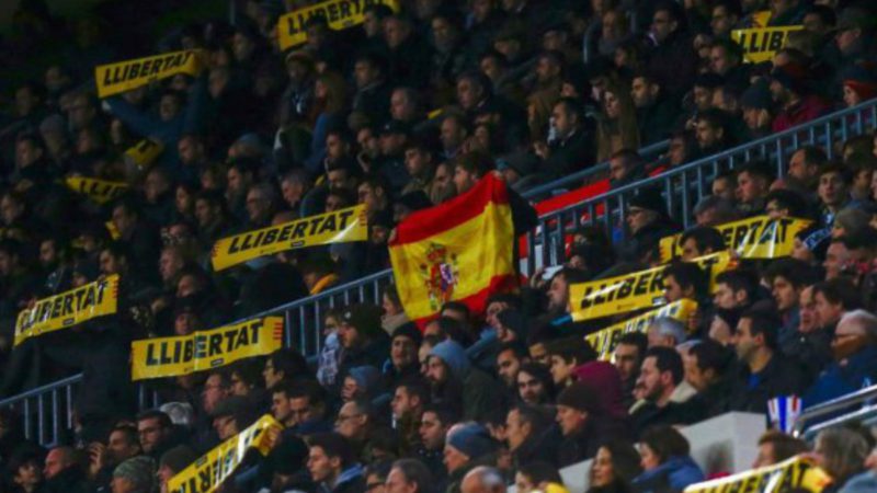 Un valiente luce la enseña nacional en el aquelarre separatista del Camp Nou