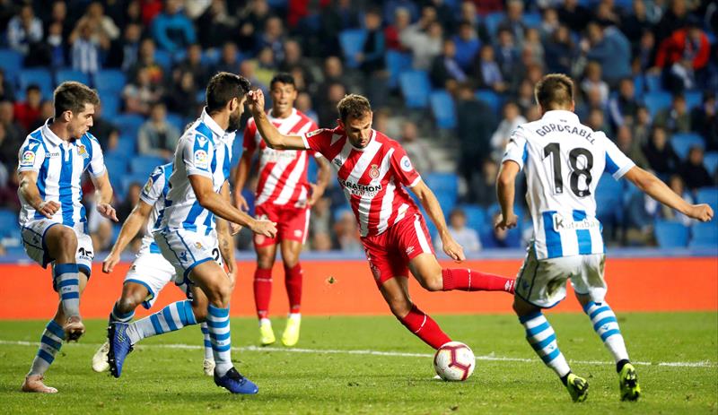 El delantero uruguayo del Girona, Christian Ricardo Stuani, intenta llevarse el balón ante los defensores de Real Sociedad durante el encuentro disputado esta noche en el estadio de Anoeta, en San Sebastián. EFE/Juan Herrero.