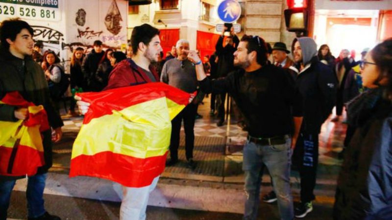 Un grupo de antifascistas increpa a dos votantes de VOX que portan la bandera de España. VOX/ Sevilla