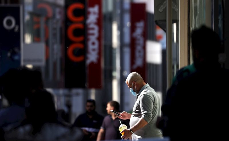 Un hombre consulta su teléfono móvil en una calle de Essen Alemania.