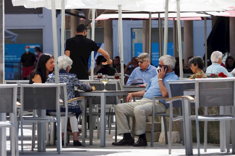 Personas disfrutan de un soleado día en la terraza de un restaurante en la plaza de la Rinconada, este domingo en Valladolid.