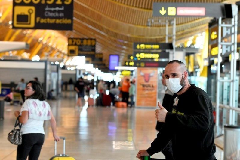 Pasajeros se protegen con mascarillas en la terminal 4 del aeropuerto Adolfo Suarez Madrid Barajas.