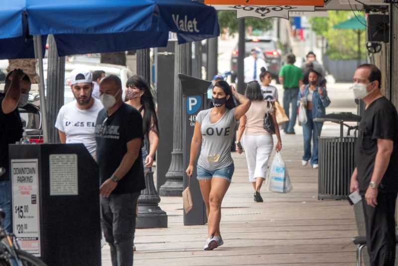Personas caminan con mascarillas por el centro de Miami, Florida
