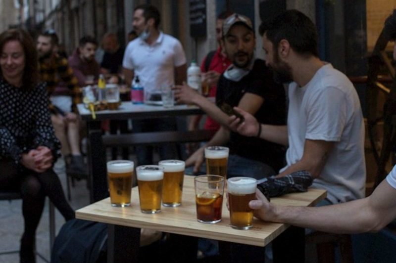 Varias personas bebiendo cerveza en un bar