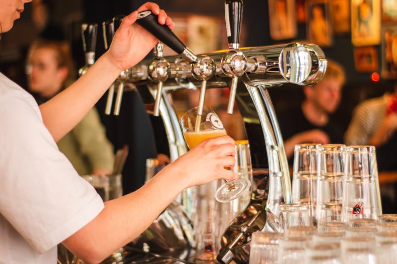 Un camarero sirviendo una cerveza en un bar