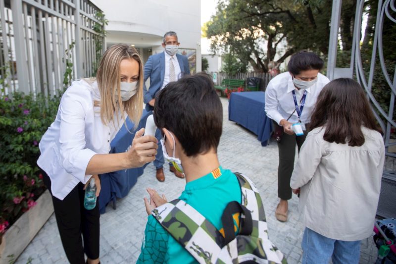 Una trabajadora toma la temperatura a un niño a la entrada del colegio privado internacional American School of Barcelona, en Esplugues de Llobregat (Barcelona).