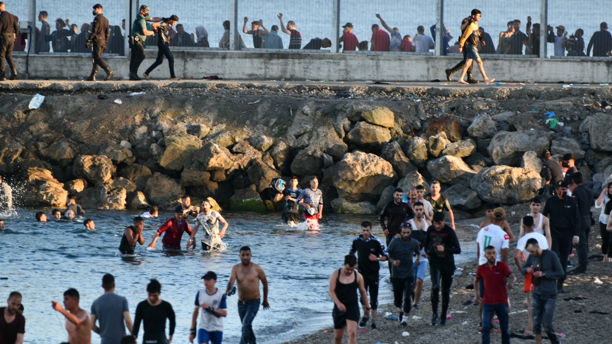 Inmigrantes ilegales caminan por la playa del Tarajal (Ceuta). Europa Press