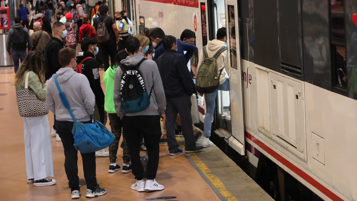 Un gran número de pasajeros entra a un tren de Renfe en Madrid