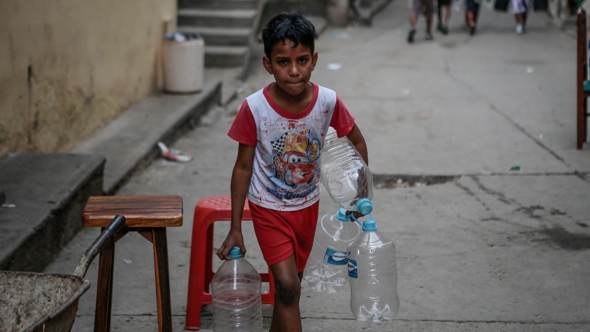 Un niño venezolano carga varias botellas vacías para llenarlas de agua en un barrio sin acceso al suministro. Europa Press