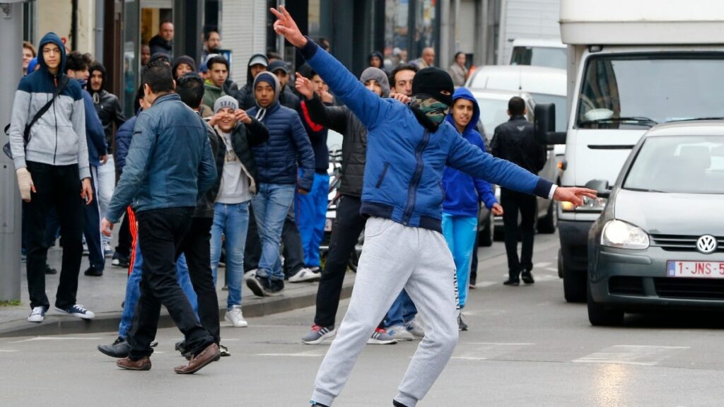 Varios jóvenes se manifiestan con la cara tapada en el distrito bruselense de Molenbeek. (Reuters)