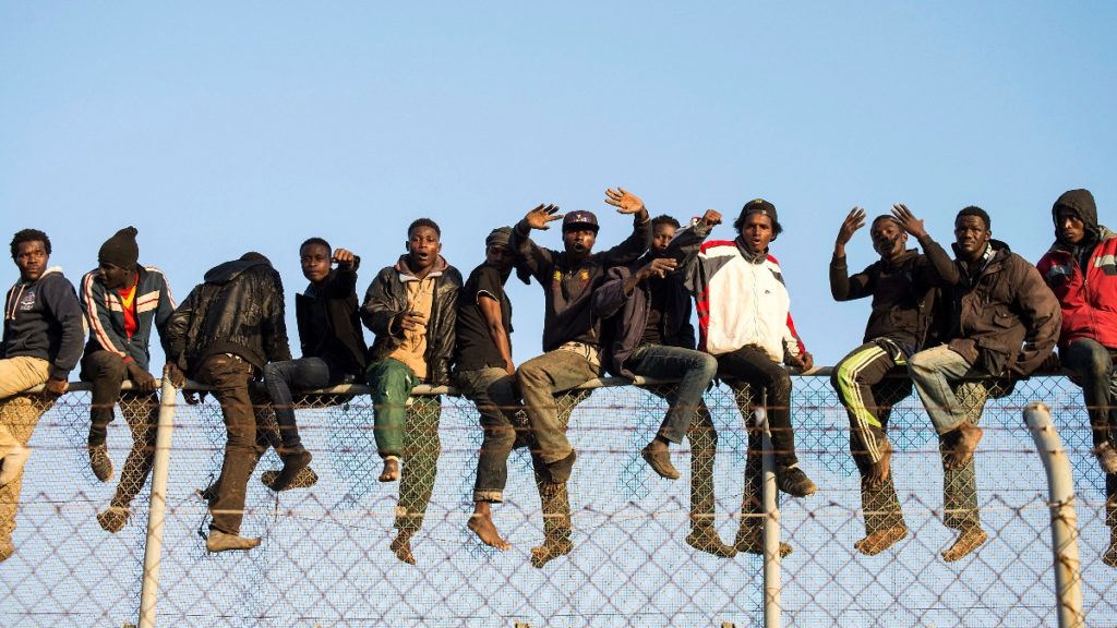 Inmigrantes sobre la valla que separa Melilla de Marruecos. Reuters