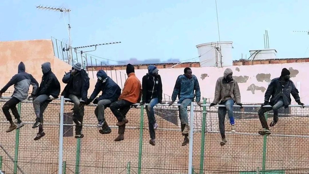 Inmigrantes ilegales subidos a la valla de Ceuta.