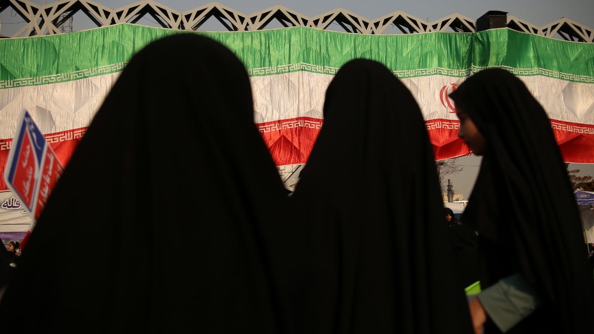 Tres mujeres junto a la bandera de Irán. Europa Press