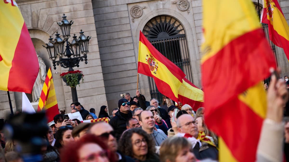 Decenas de personas con banderas de España participan durante una manifestación contra el chantaje separatista la plaza de San Jaime en Barcelona. Europa Press