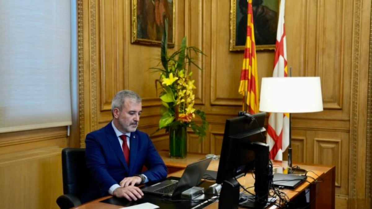 El alcaldes socialista de Barcelona, Jaume Collboni, en su despacho junto a la bandera de Barcelona y la bandera catalana. Fuente: Ayuntamiento de Barcelona