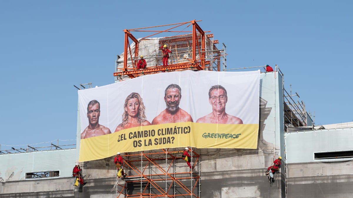 Greenpeace acusa a los cuatro candidatos electorales de ignorar el cambio climático con una lona en la Puerta de Alcalá