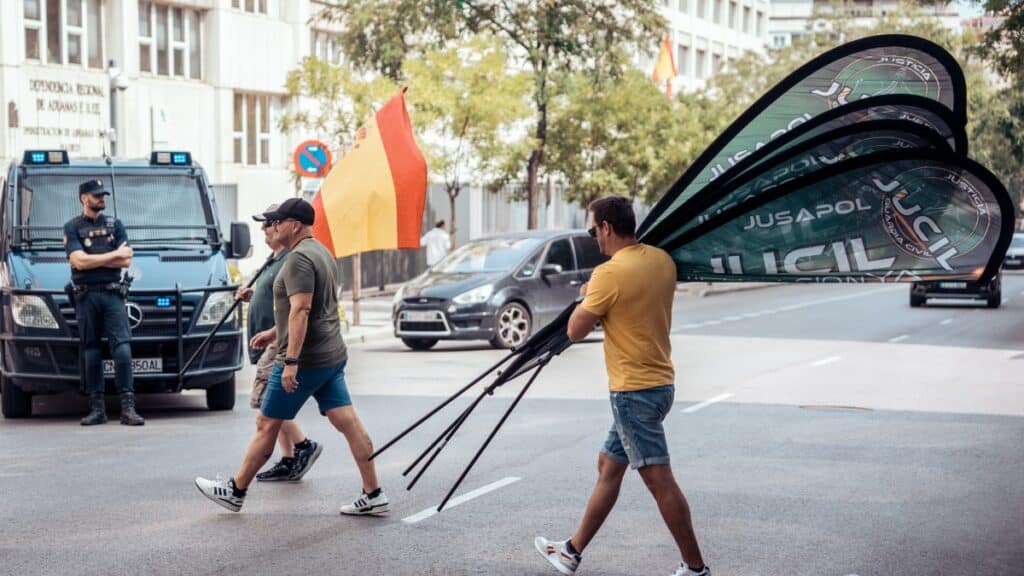 Varias personas retiran carteles durante una protesta convocada por la Asociación Profesional Justicia para la Guardia Civil (JUCIL), frente a la Dirección General de la Guardia Civil. Europa Press
