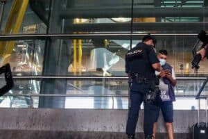 Agente de policía identifica a un pasajero llegado de Marruecos en Barajas. Europa Press.