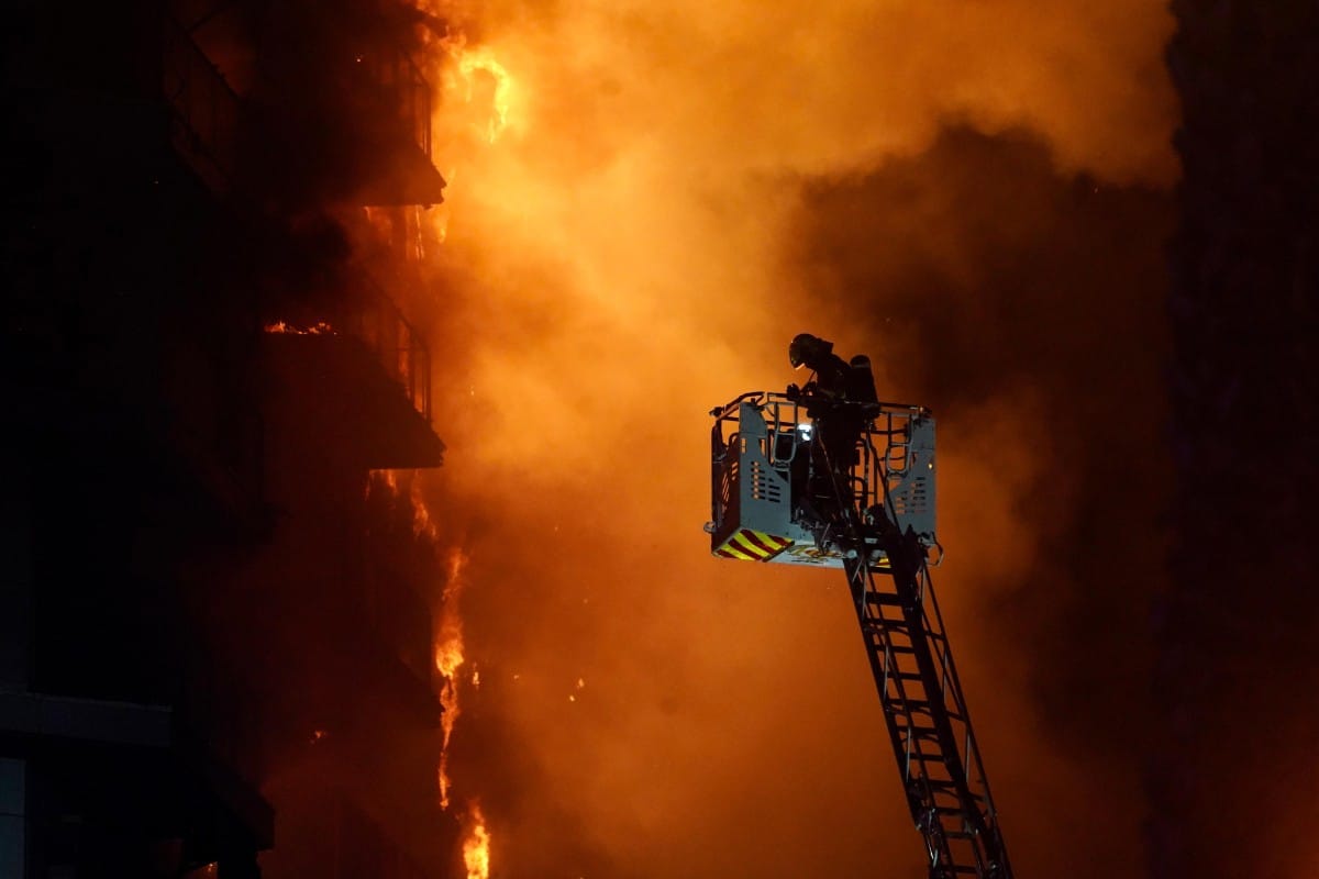 Los bomberos rescatan a dos personas atrapadas en el interior del edificio incendiado en Valencia