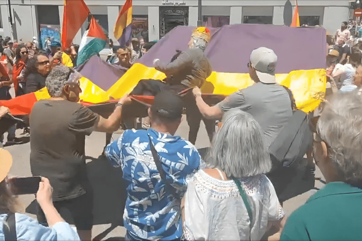 Un grupo de manifestantes republicanos mantean y arrojan al suelo un muñeco del Rey Felipe VI