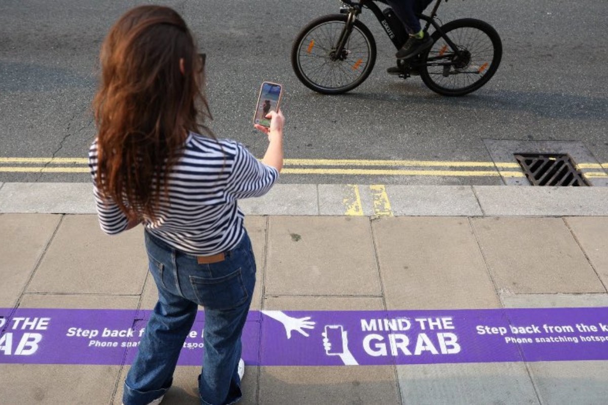 Londres pinta las aceras de la ciudad con líneas moradas ante el auge de robos de teléfonos móviles: «Cuidado con el tirón»