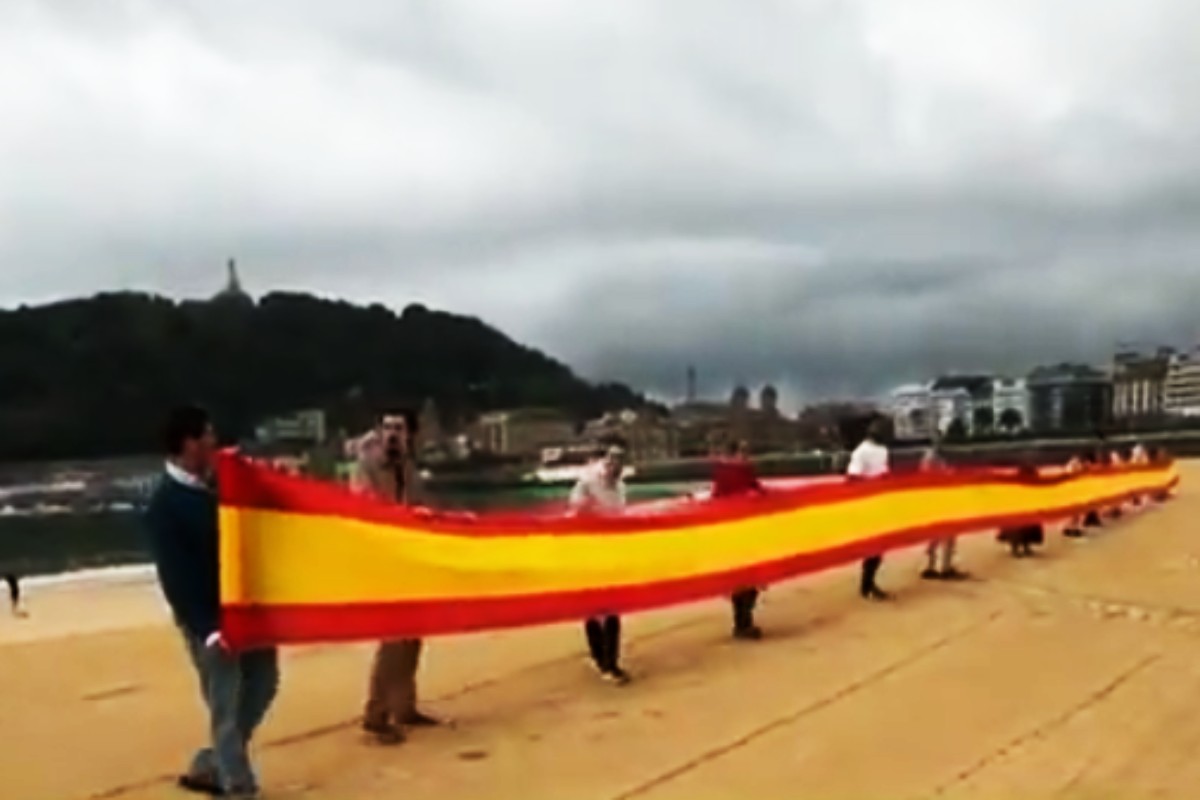 VOX hace frente a los proetarras y despliega una gran bandera de España en la Playa de la Concha de San Sebastián: «Es el símbolo que nos une a todos los españoles»