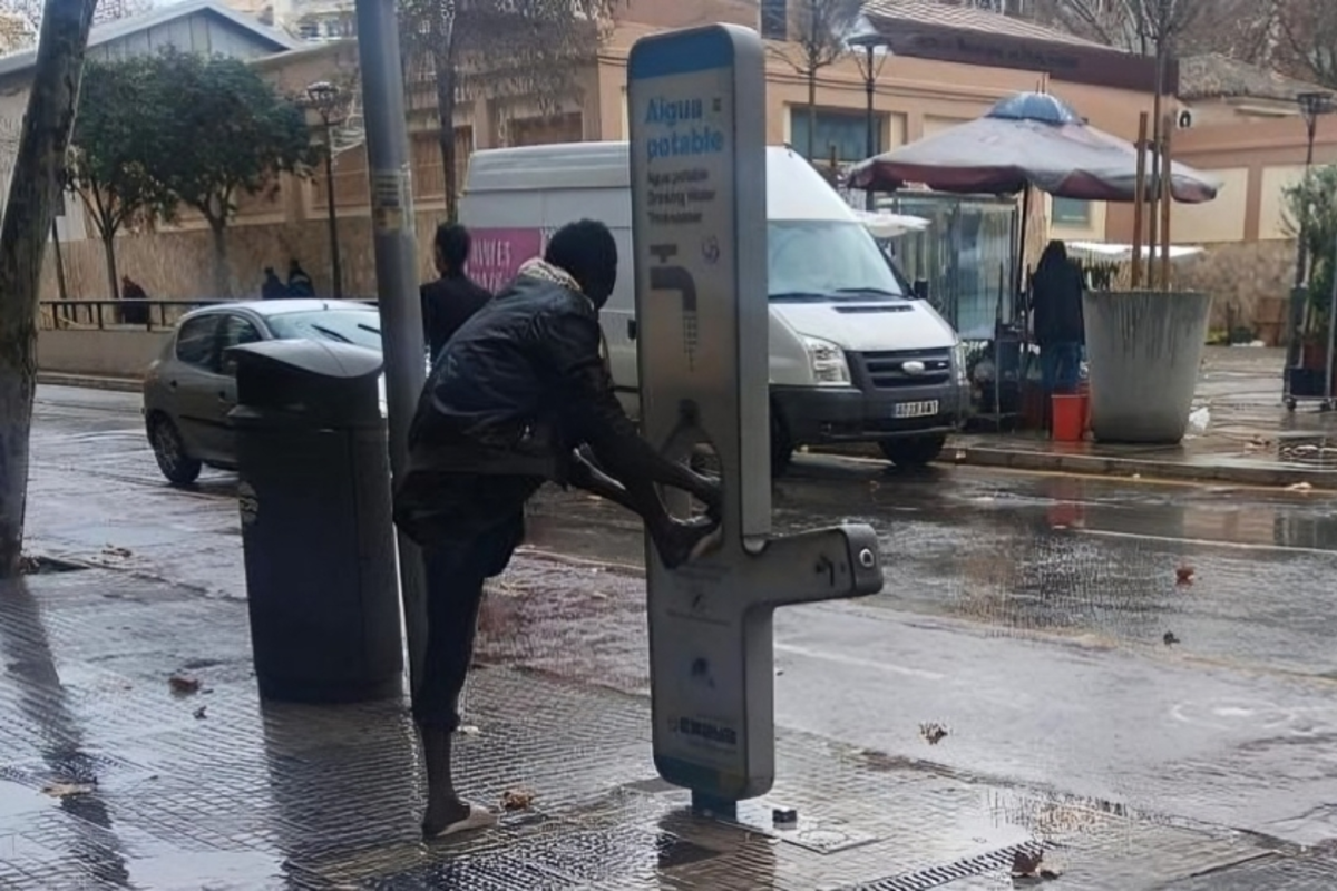 Inmigrantes africanos se lavan los pies en las fuentes de agua de Palma que el Ayuntamiento instaló para beber